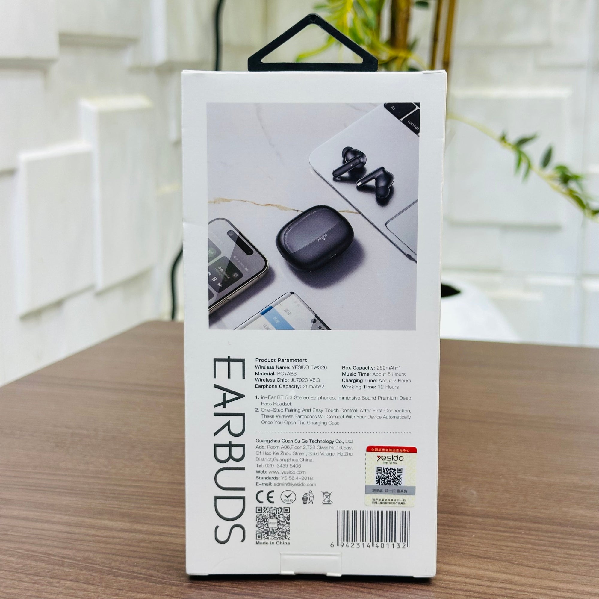 Box of earbuds with product images and text on a wooden surface