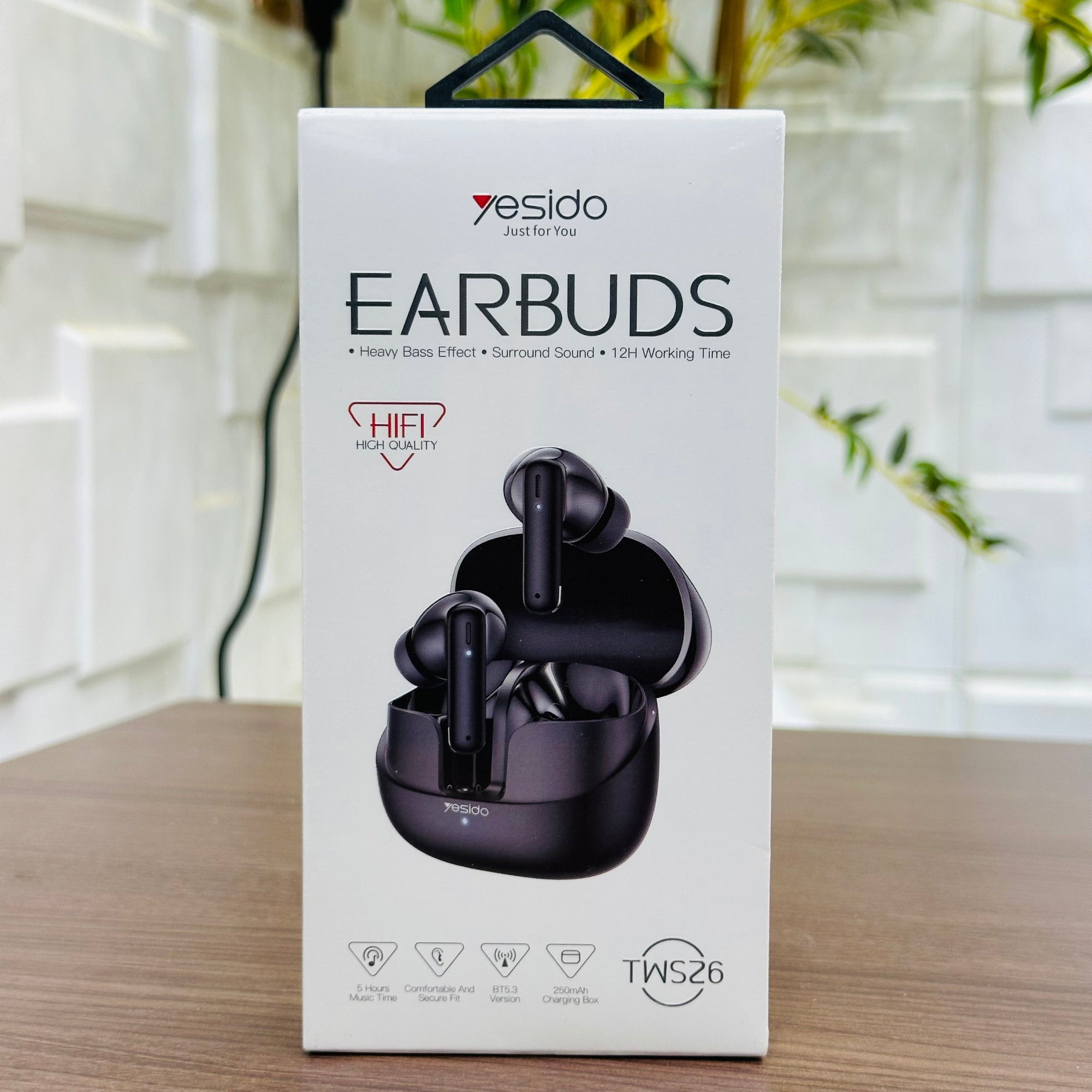Box of Yesido earbuds with a blurred indoor background
