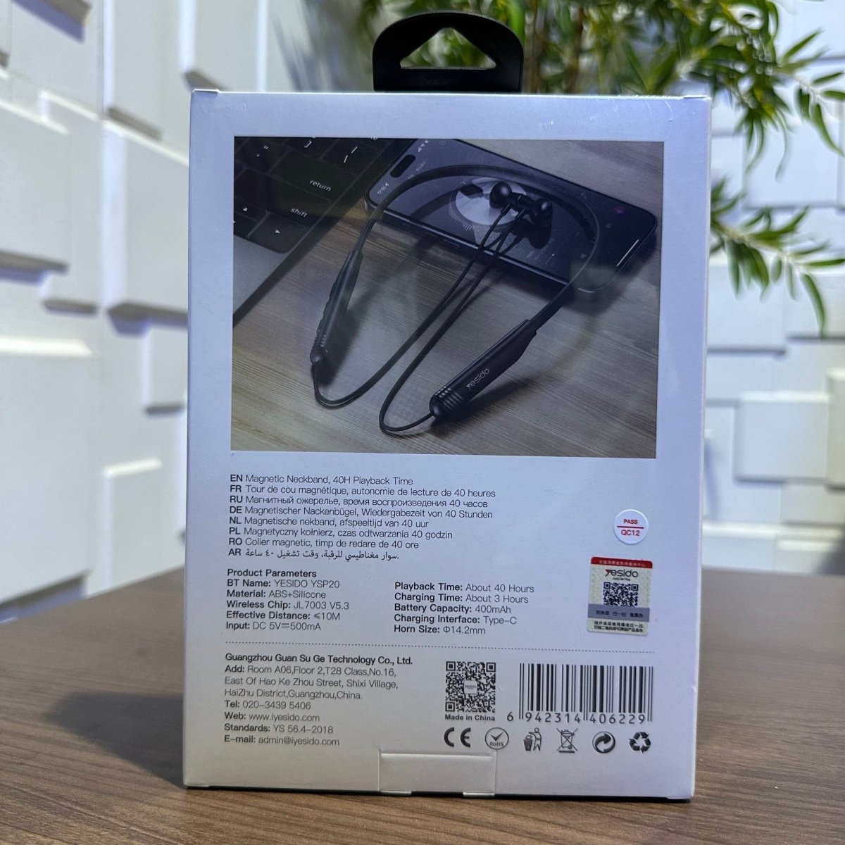 Product packaging with a phone and earbuds on a wooden surface
