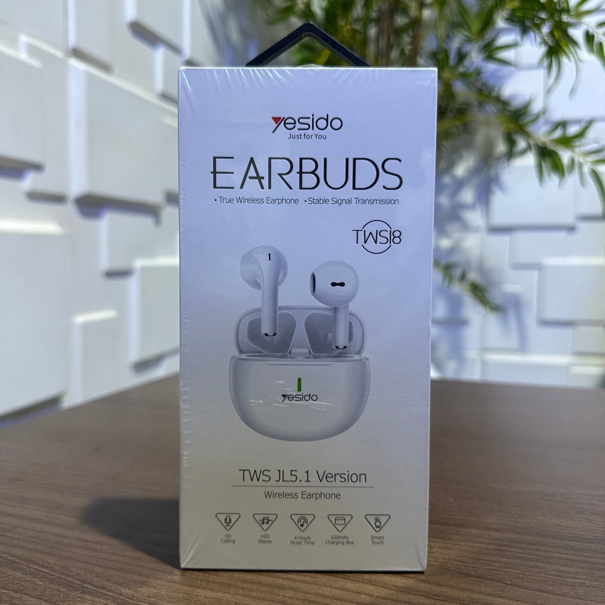 Yesido earbuds packaging box on a wooden surface with a blurred indoor background