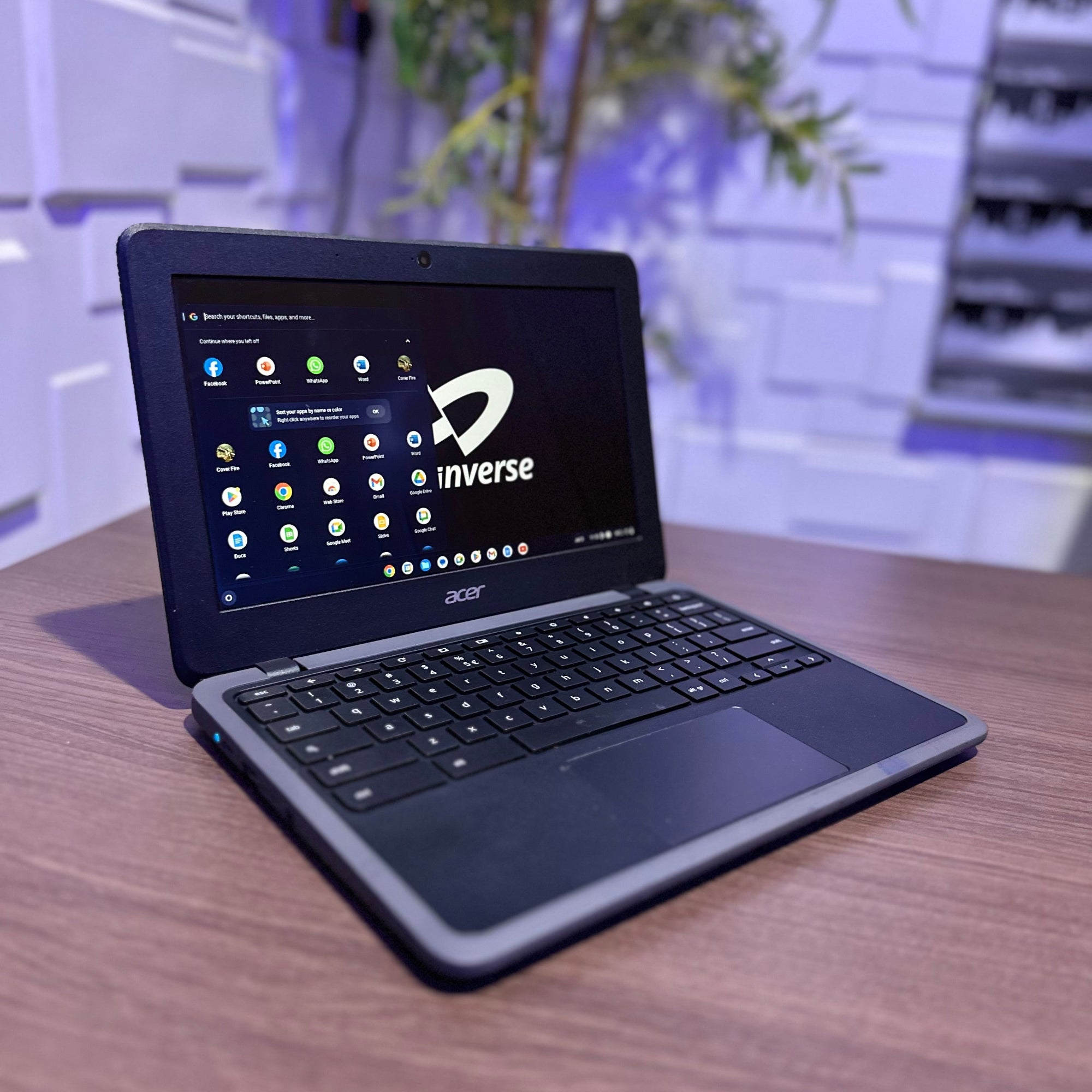 Acer laptop with keyboard cover on a wooden surface, brand 'inverse' visible