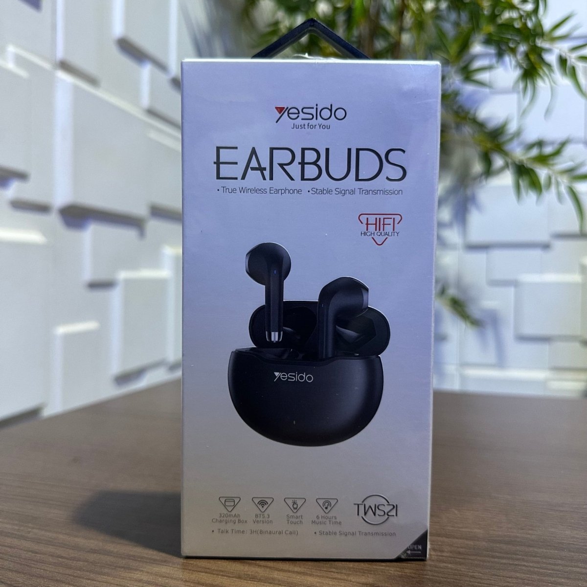 Yesido earbuds packaging on a wooden surface with a blurred background
