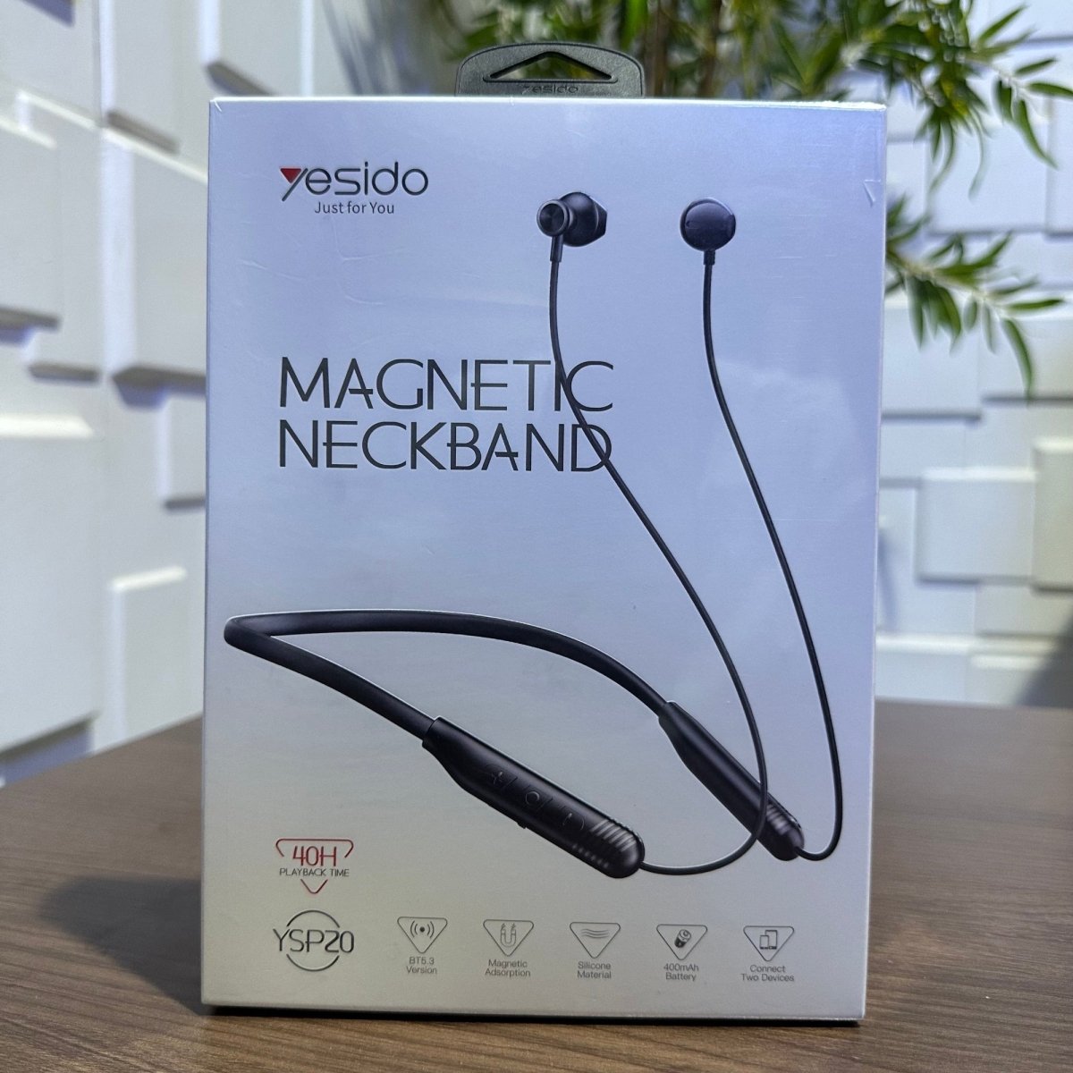 Yesido magnetic neckband packaging on a wooden surface with a blurred indoor background