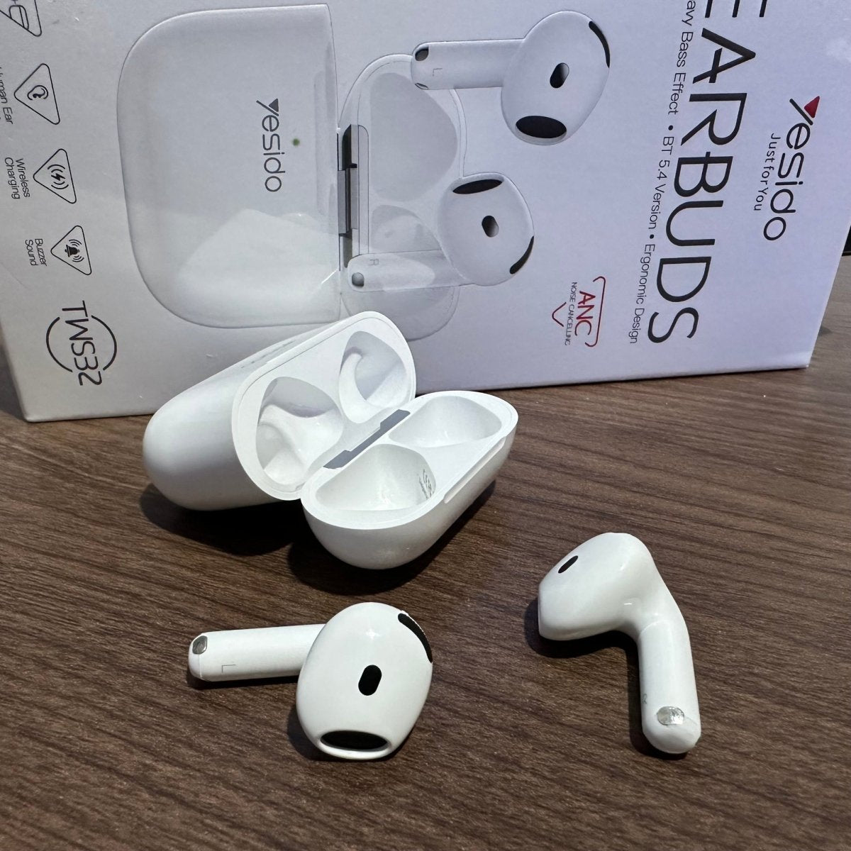 White wireless earbuds with charging case on a wooden surface, with 'YESIDAO' packaging in the background.