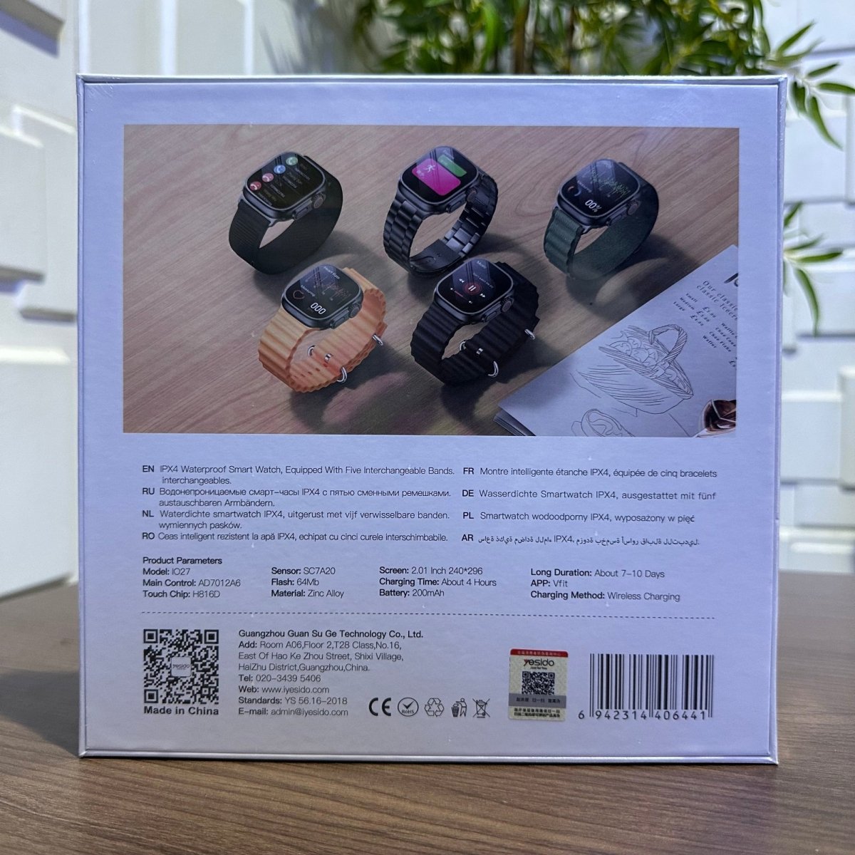 Product packaging with multiple smartwatches displayed on a wooden surface.