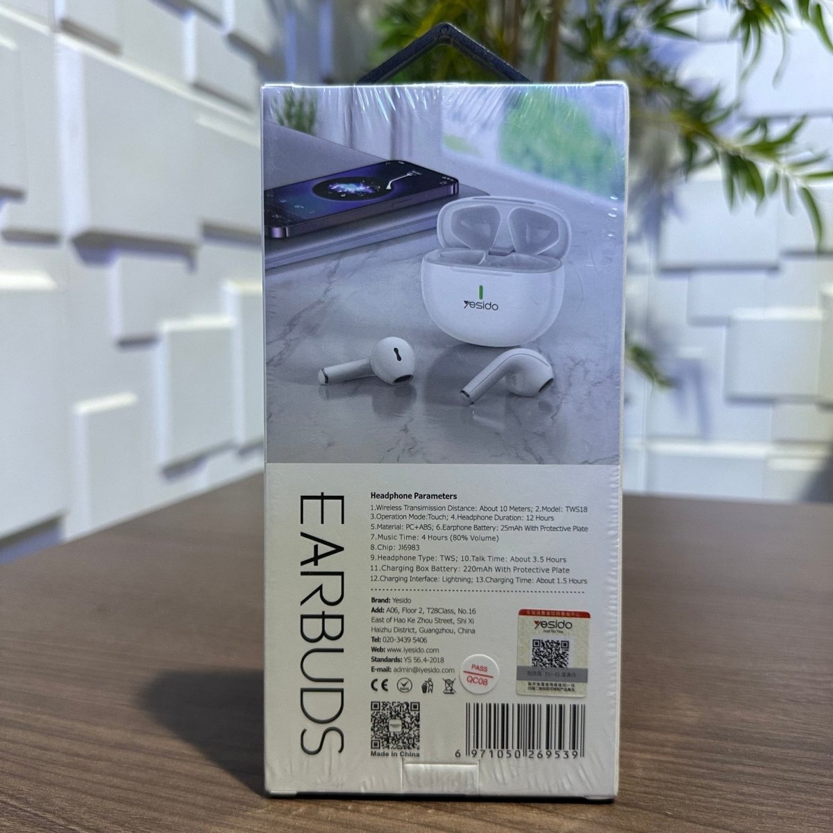 Packaging of earbuds with product images and text on a neutral background