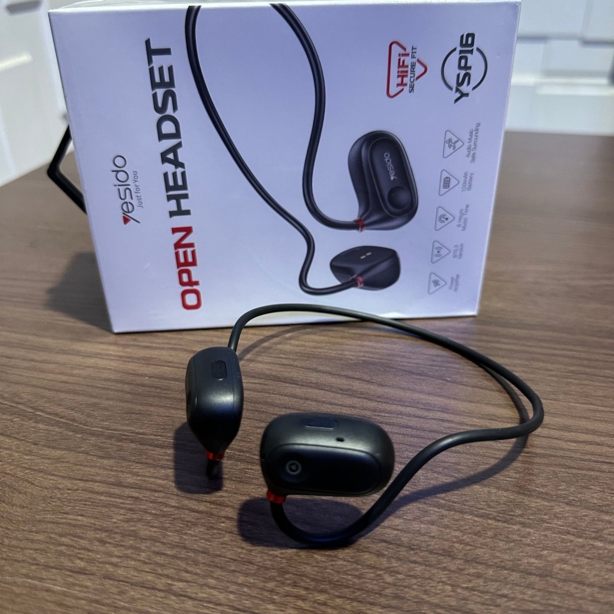 Black open headset with Ysagio branding on a wooden surface