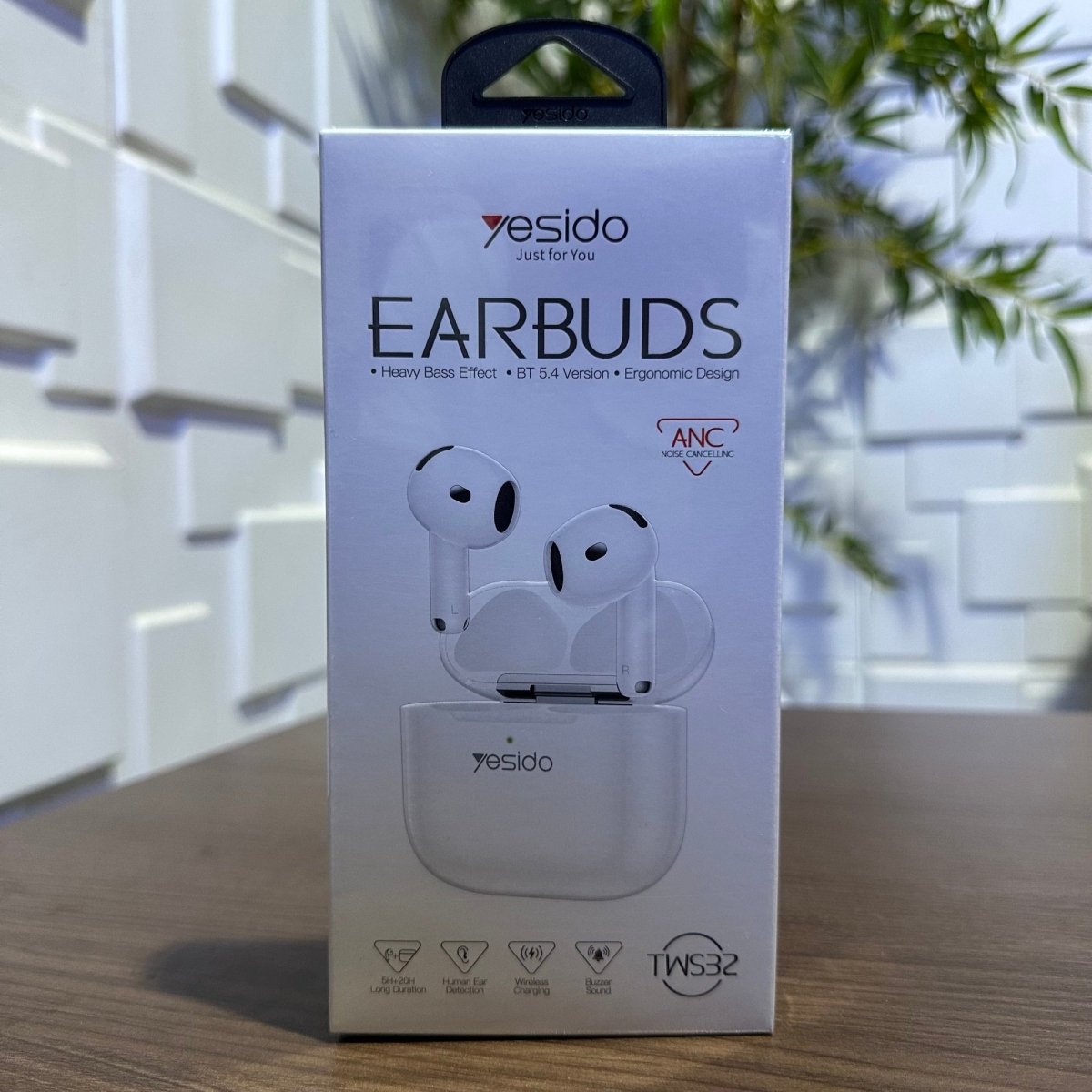Yesido earbuds packaging on a wooden surface with a blurred indoor background