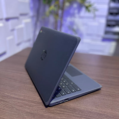 Black laptop on a wooden surface with a blurred indoor background